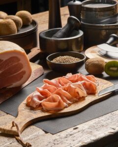 Prosciutto crudo San Daniele prolongo DOP a fette su un tagliere